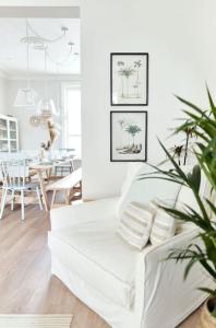 a living room with a white couch and a table at The Beach House Sleeps 20 & 4 mins to the beach in Bournemouth