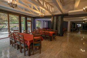 a dining room with tables and chairs and windows at Popas Turistic Transfagarasan in Cîrţişoara