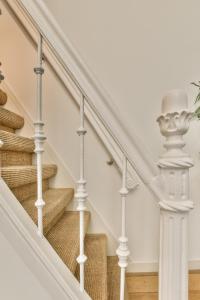 una escalera con barandillas blancas en una casa en Amsterdam Alley Apartment, en Ámsterdam
