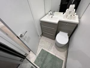 a small bathroom with a toilet and a sink at Streatham House - 2 Bedroom - Sleeps 6 - Free WiFi in Streatham Vale +11 photos
