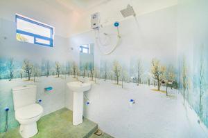 La salle de bains est pourvue de toilettes et d'une douche avec des arbres sur le mur. dans l'établissement Apartments by Tyzon, à Aluthgama