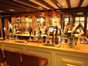 a bar in a restaurant with a counter with flowers at Pilgrims Hotel in Canterbury
