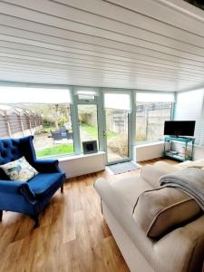 a living room with a couch and a tv at Riverside Bungalow - direct river access! in Ystradgynlais