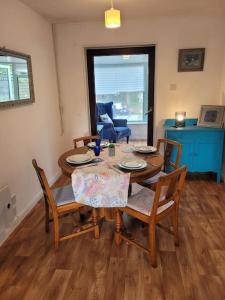 a dining room with a wooden table and chairs at Riverside Bungalow - direct river access! in Ystradgynlais