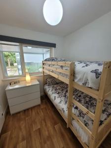 a bedroom with two bunk beds and a window at Riverside Bungalow - direct river access! in Ystradgynlais