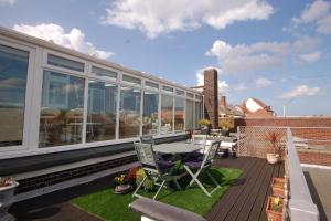 een patio met een tafel en stoelen op een balkon bij Sky View in Sheringham