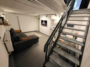 una escalera que conduce a una sala de estar con sofá en Kant 99 XL en Berlín