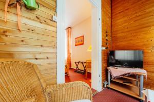 ein Wohnzimmer mit Holzwänden und einem Flachbild-TV in der Unterkunft Theo's Bähnli in Braunlage