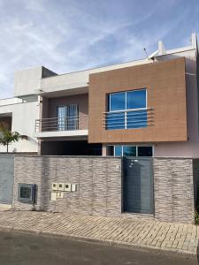 une maison avec une clôture devant elle dans l'établissement Alojamento 2Ás, à Praia
