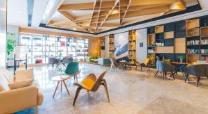 a lobby with chairs and tables in a library at Atour Hotel Putuo Zhoushan in Zhoushan