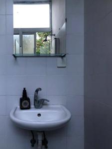 a bathroom with a sink and a mirror and a window at Studio 91 By IsrApart in Ramat Gan
