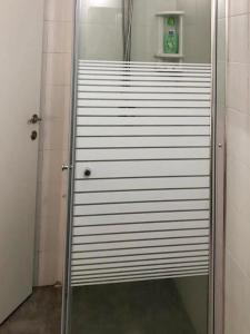 een douchecabine met een glazen deur in de badkamer bij Studio 91 By IsrApart in Ramat Gan