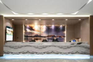 Tre uomini seduti in una sala conferenze con un grande dipinto sul muro di Atour Hotel (Shanghai International Tourism and Resorts Zone XiuYan Road) a Shanghai
