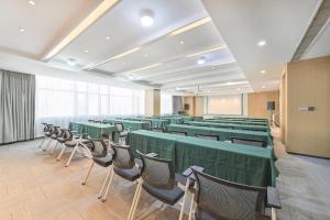 une salle de conférence avec des tables et des chaises vertes dans l'établissement Atour Hotel Railway Station Dalian, à Dalian