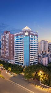 un gran edificio con ventanas azules en una ciudad en Atour Hotel Hailian Fuzhou, en Fuzhou