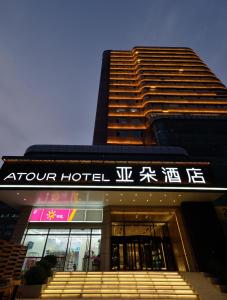 a hotel with a sign on the front of a building at Atour Hotel Railway Station Dalian in Dalian