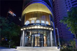 un grand bâtiment avec un panneau la nuit dans l'établissement Atour Hotel Headquarter Base Beijing, à Pékin