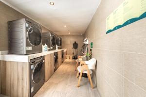 a laundry room with washing machines and a table and chairs at Atour Hotel Potala Palace Lhasa in Lhasa