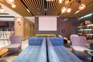 una sala de reuniones con un sofá azul en una habitación en Atour Hotel (Zhangjiakou High-tech Zone) en Zhangjiakou