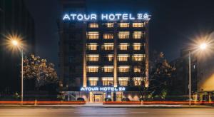 un bâtiment d'hôtel avec un panneau sur celui-ci la nuit dans l'établissement Atour Hotel Zhejiang University East Fengqi Road, à Hangzhou