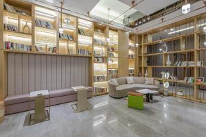 uma biblioteca com um sofá e prateleiras de livros em Atour Hotel Chengdu North Renmin Road em Chengdu