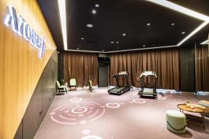 een kamer met een fitnessruimte met een loopband en stoelen bij Atour Hotel Xiamen Huandao South Road in Xiamen
