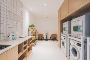 a laundry room with a washer and dryer at Atour Hotel North Bund Shanghai in Shanghai