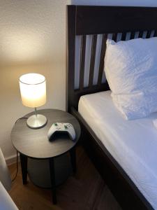 Schlafzimmer mit einem Bett und einem Tisch mit einer Lampe in der Unterkunft Wohnung im Universitätsring in Halle an der Saale