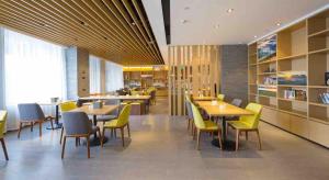 restauracja z żółtymi krzesłami, stołami i stolikiem stołowym w obiekcie Atour Hotel (Zhangjiakou High-tech Zone) w mieście Zhangjiakou