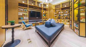 a large living room with a blue couch and a table at Atour Hotel Tianjin Binhai Second Avenue Branch in Binhai