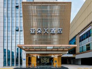a building with a sign on the side of it at Atour X Hotel Wuxi New Zone Gelunbu Plaza in Wuxi