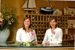 two women in white uniforms sitting at a table in a room at Hotel Montecarlo in Bibione