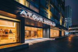 una tienda frente a un edificio con un cartel. en Atour Hotel North Bund Shanghai en Shanghái