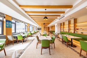 拉薩的住宿－拉萨布达拉宫亚朵酒店，用餐室配有桌子和绿色椅子