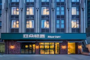 a facade of an apartment building with a blue sign at Atour Light Hotel Shandong Road CBD Qingdao in Qingdao