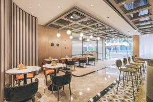 a restaurant with tables and chairs and windows at Atour Hotel North Bund Shanghai in Shanghai