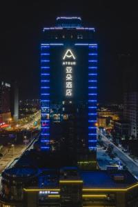 a lit up building with a sign on it at night at Atour Hotel Shaoxing Jinghu City Hall Basketball Theme in Shaoxing