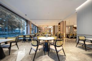 a restaurant with tables and chairs and a large window at Atour Hotel Shanghai Hongqiao Xinzhuang Business District in Shanghai