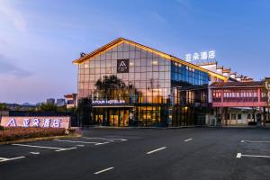 een groot glazen gebouw met een straat ervoor bij Atour Hotel Huangshan Tunxi Old Street Xin an River in Huangshan Scenic Area