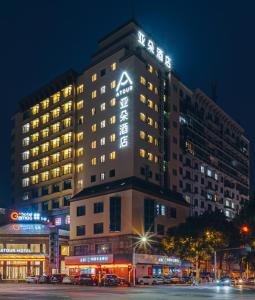 a hotel building with a lit up sign on it at Atour Hotel Shangxing Lu Xun s Hometown in Shaoxing