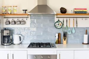 a kitchen with white cabinets and a stove top oven at Augusta House in Bremer Bay