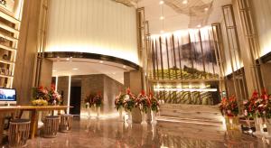 un vestíbulo con jarrones de flores en un edificio en Atour Hotel Hailian Fuzhou, en Fuzhou