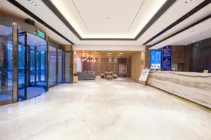 Duży hol z marmurową podłogą i szklanymi ścianami w obiekcie Atour Hotel (Zhangjiakou High-tech Zone) w mieście Zhangjiakou