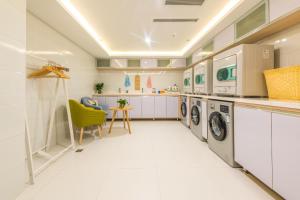 duża biała pralnia z pralką i suszarką w obiekcie Atour Hotel (Urumqi Renmin Cinema) w mieście Urumczi