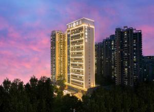 un bâtiment éclairé dans une ville à crépuscule dans l'établissement Atour S Hotel Shenzhen Futian Port, à Shenzhen