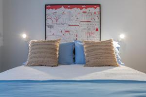 1 cama con almohadas azules y blancas y pared en Casa Paradiso by Wonderful Italy, en Turín
