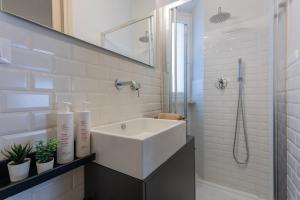 y baño blanco con lavabo y ducha. en Casa Paradiso by Wonderful Italy, en Turín