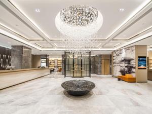 a lobby with a large chandelier and a large bowl at Atour Hotel Hangzhou Qiandao Lake Central Dock in Chun'an