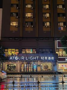 a building with a sign in front of a store at Atour Light Hotel Shenyang High-Speed Railway Station in Shenyang