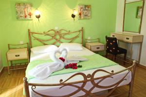 ein Bett mit zwei Handtüchern und zwei Schwänen darauf in der Unterkunft Coralli Rooms & Restaurant in Elafonisos